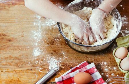 enfant qui pétri une pâte en atelier cuisine ludique