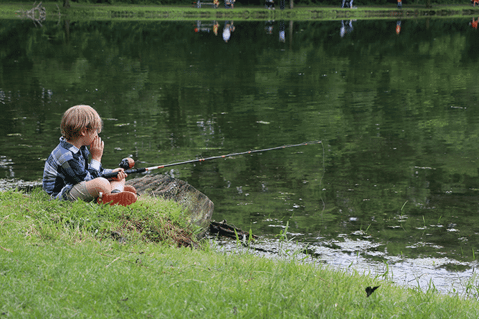 Enfant pêche au bord d'un lac