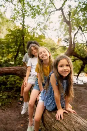 enfants su une tron d'arbre dans la nature classe verte