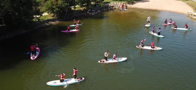 élèves en activité paddle sur un plan d'eau en classe de découvertes