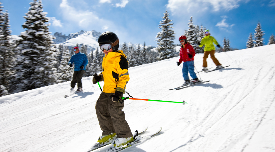 Élèves qui descendent une piste de ski alpin en classe de neige